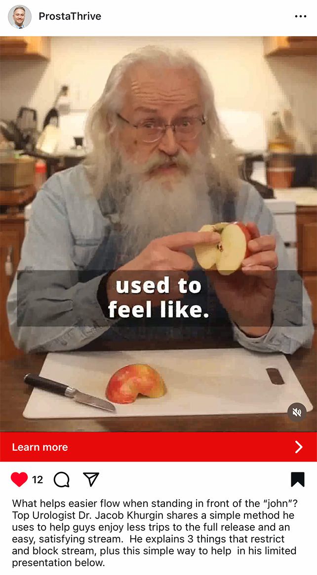 old man with long gray beard holding apple half